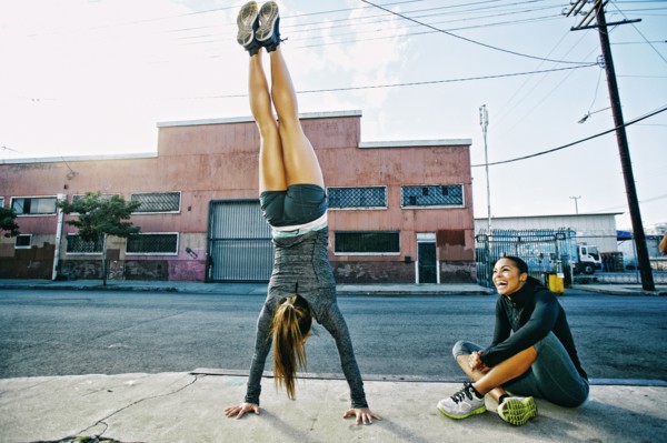 Athlete doing handstand on sidewalk