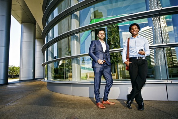 Businessmen smiling outside office building