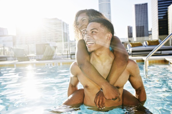 Smiling couple enjoying urban swimming pool