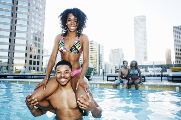 Smiling friends enjoying urban swimming pool