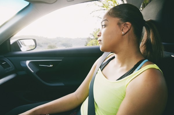Mixed Race woman daydreaming in car