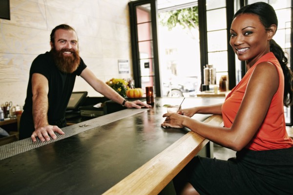 Smiling bartender and customer at bar