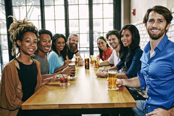 Smiling friends posing at table in bar