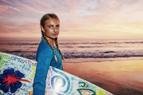 Caucasian woman carrying surfboard at beach