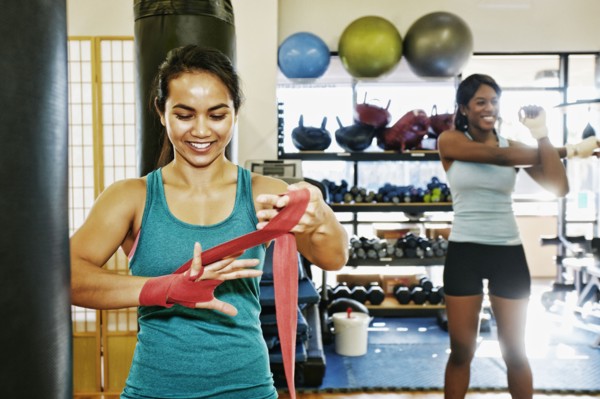 Woman wrapping hand in gymnasium