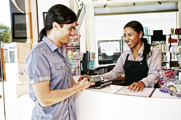 Customer paying in hair salon with cell phone