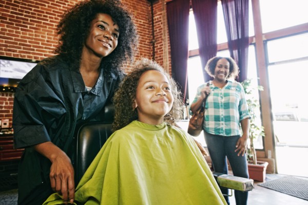 Smiling hairdresser and customers in hair salon