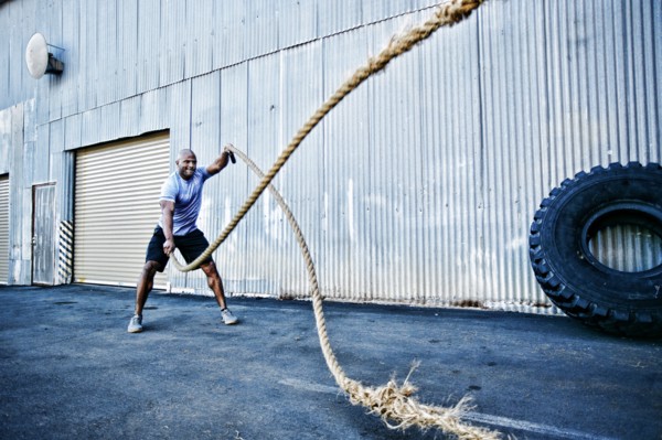 Black man working out with heavy ropes outdoors