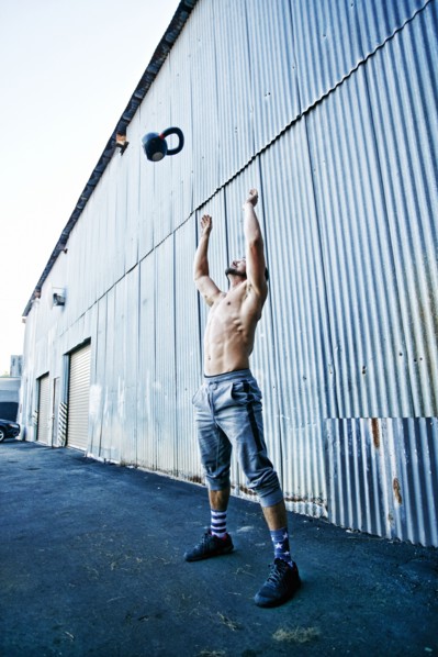 Caucasian man throwing kettlebell outdoors