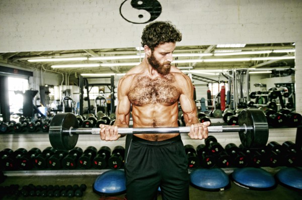 Mixed Race man lifting barbell in gymnasium