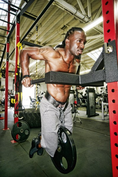 Black man doing weighted push-up in gymnasium