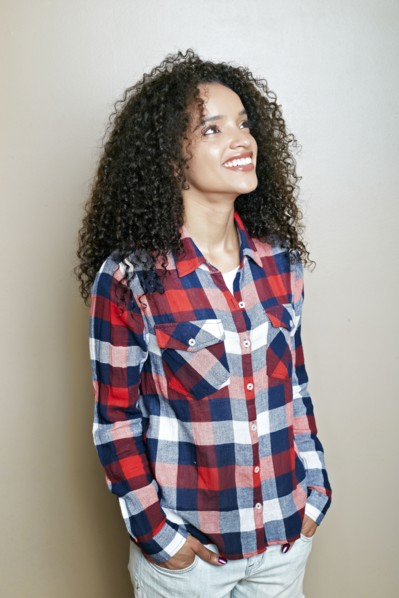 Hispanic woman with hands in pockets looking up