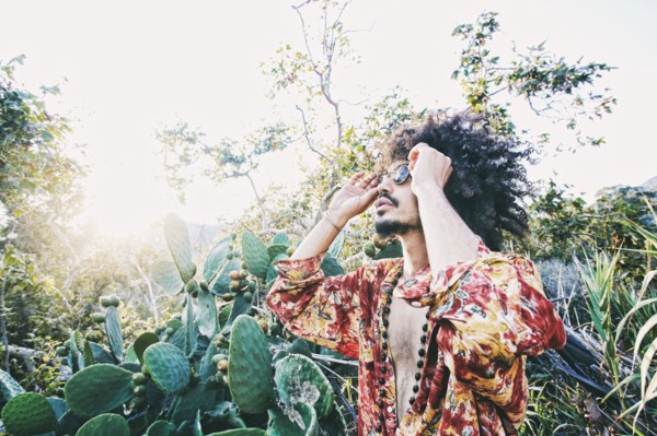 Mixed Race man wearing sunglasses near cactus