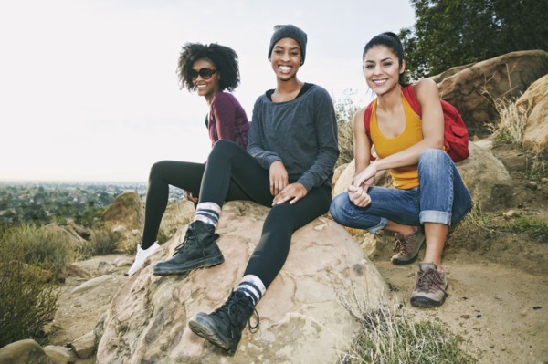 Portrait of smiling women sitting on rock