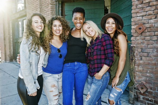 Women posing on sidewalk in city