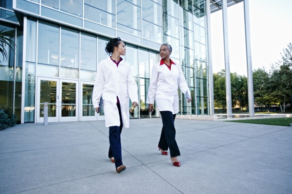 Doctors walking and talking outdoors at hospital