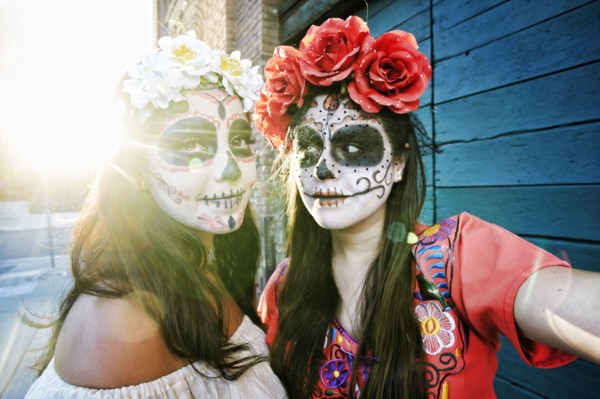 Women on sidewalk wearing skull face paint