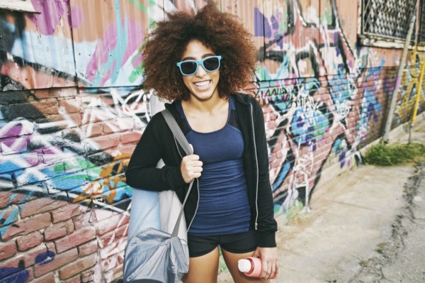 Hispanic woman standing near graffiti wall