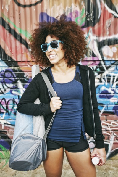 Hispanic woman standing near graffiti wall