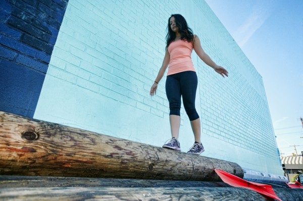 Mixed race woman walking on log