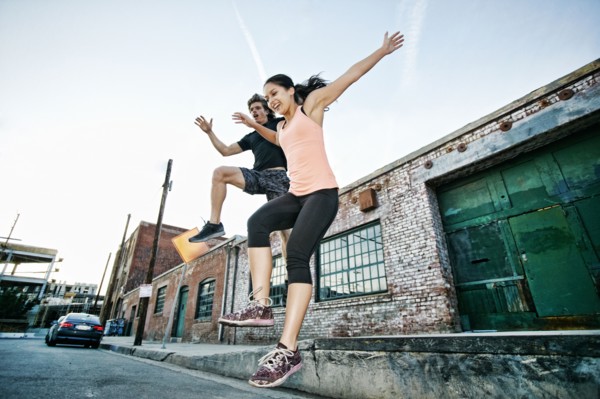 Couple jumping off loading dock
