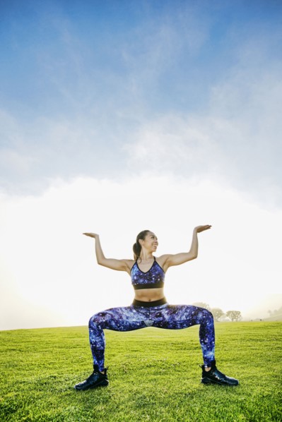 Mixed race woman squatting in field