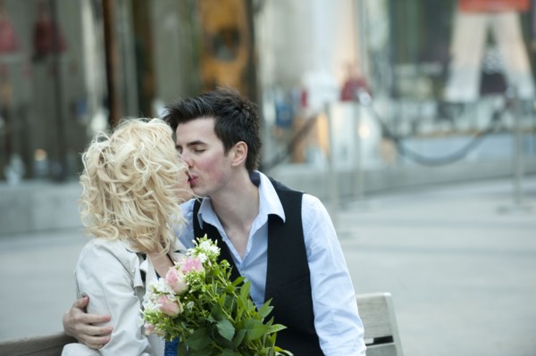 Caucasian couple kissing on bench