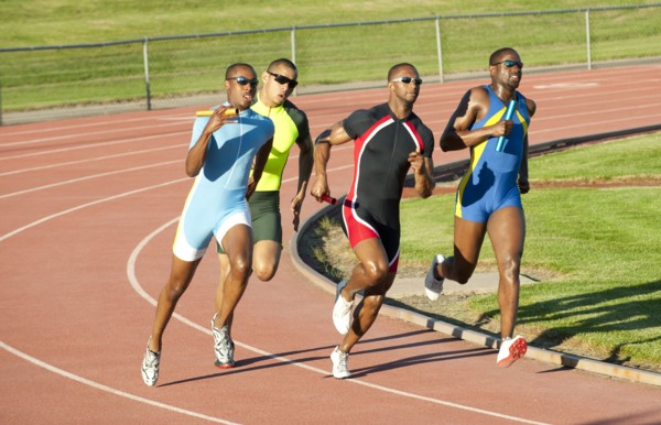 Relay racers running on track in race