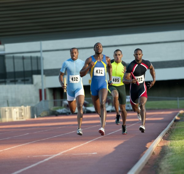 Relay racers running on track in race