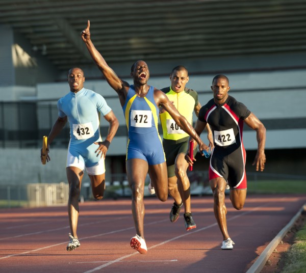 Relay racer crossing finish line on track in race