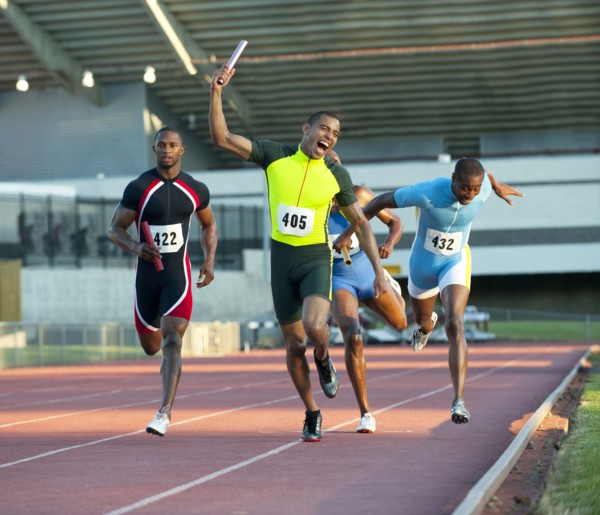 Relay racer crossing finish line on track in race