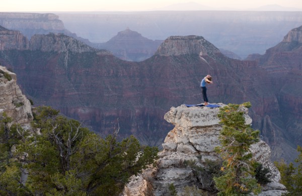 Caucasian woman practicing yoga on top of rock formation
