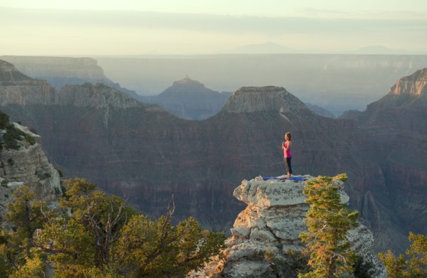 Caucasian woman practicing yoga on top of rock formation