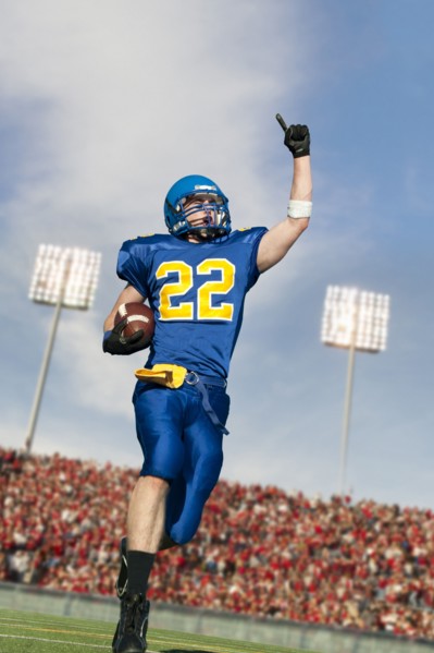 Caucasian football player running with ball