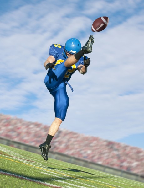 Caucasian football player kicking ball