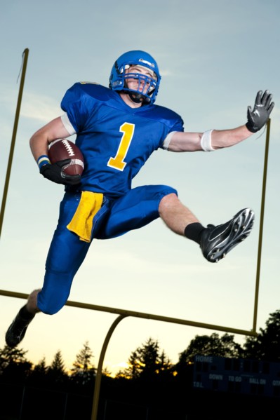 Caucasian football player running with football