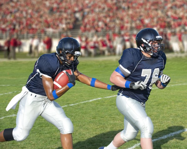 Football players passing ball
