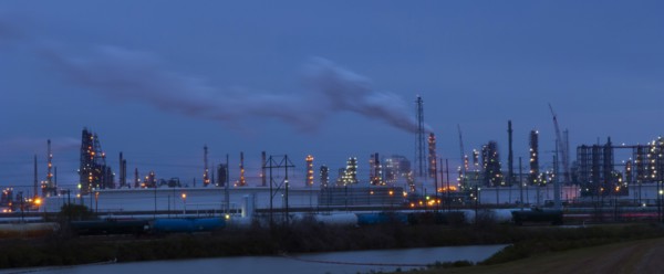Factory near lake illuminated at night