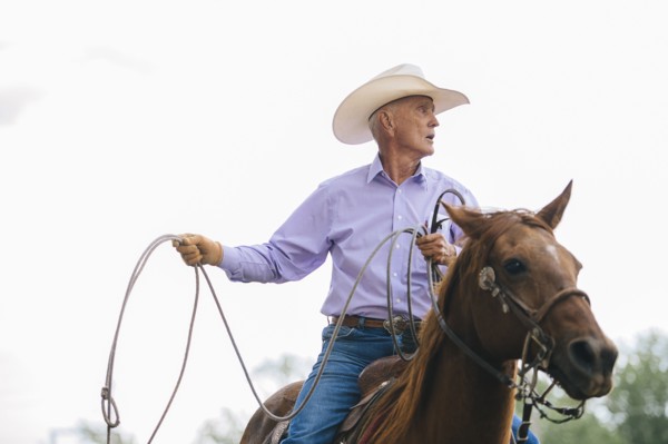Caucasian cowboy riding horse in rodeo