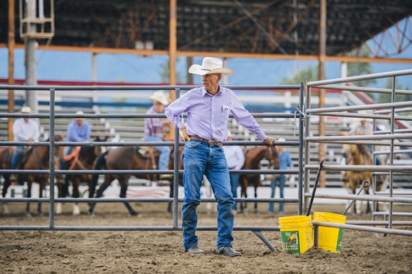 Caucasian cowboy standing at rodeo fence