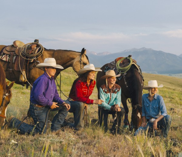 Cowboy and cowgirls with horses on ranch