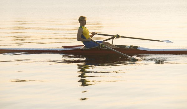 Caucasian man rowing on lake