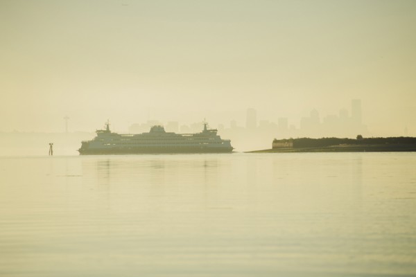 Cruise ship near city skyline at sunset