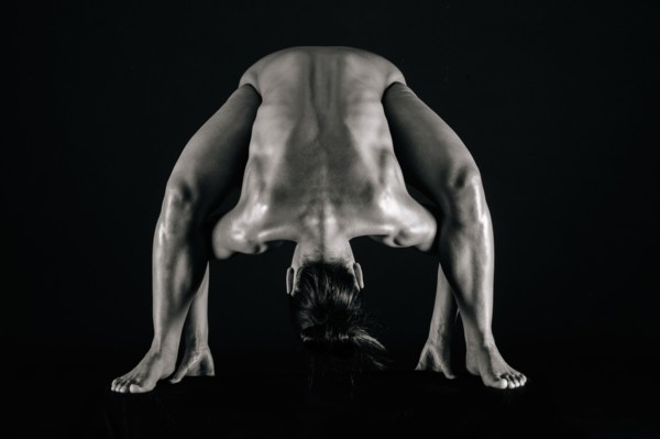 Naked muscular Mixed Race woman bending forward