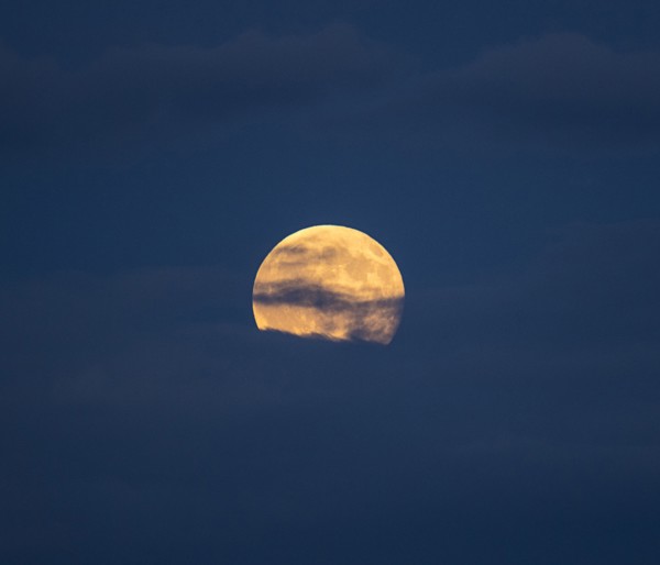 Clouds in sky in front of full moon