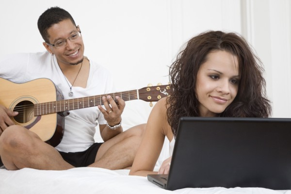 Hispanic couple relaxing on bed