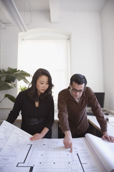 Multi-ethnic businesspeople looking at blueprints
