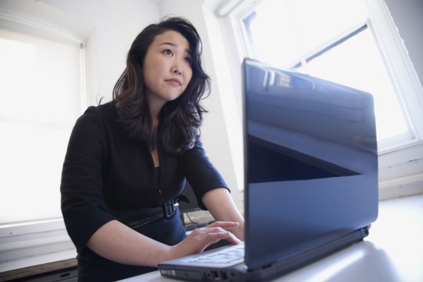 Asian businesswoman typing on laptop
