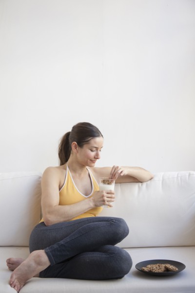 Caucasian woman having milk and cookies