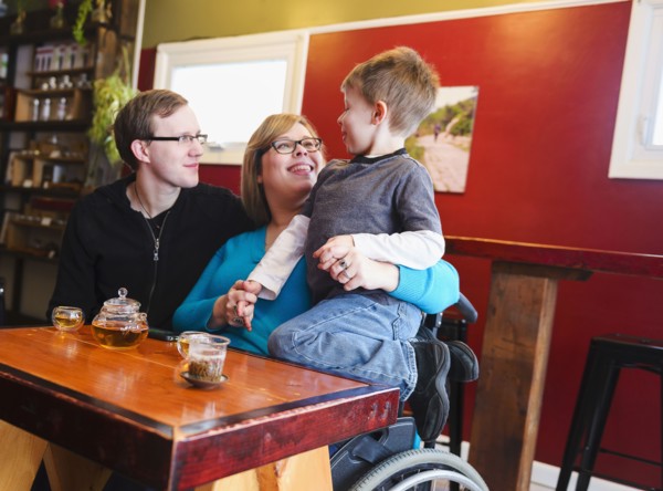 Paraplegic mother holding son in tea shop
